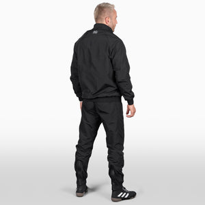 Dieser schwarze DMC Trainingsanzug bietet reflektierende Logos für zusätzliche Sichtbarkeit und Sicherheit beim Outdoor-Sport. Das strapazierfähige Material ist speziell für Kampfsportler entwickelt, die sowohl Funktionalität als auch Stil im Training suchen.