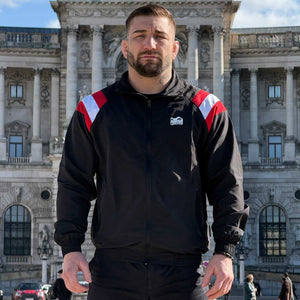 Die Phantom Athletics Track Jacket DMC Team Austria kombiniert sportlichen Retro-Style mit hochwertiger Performance für intensives Kampfsport-Training wie MMA, Boxen und Kickboxen. Das leichte, atmungsaktive Material mit Mesh-Innenfutter sorgt für optimalen Komfort und maximale Bewegungsfreiheit beim Warm-up und Sparring.
