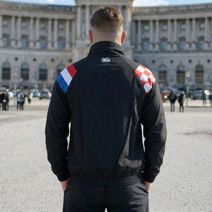 Die Phantom Athletics Track Jacket DMC Team Croatia in Schwarz kombiniert sportlichen Retro-Style mit moderner Performance für intensives Kampfsport-Training wie MMA, Boxen und Muay Thai. Das leichte, atmungsaktive Material mit Mesh-Innenfutter sorgt für optimalen Komfort und maximale Bewegungsfreiheit beim Warm-up und Sparring.