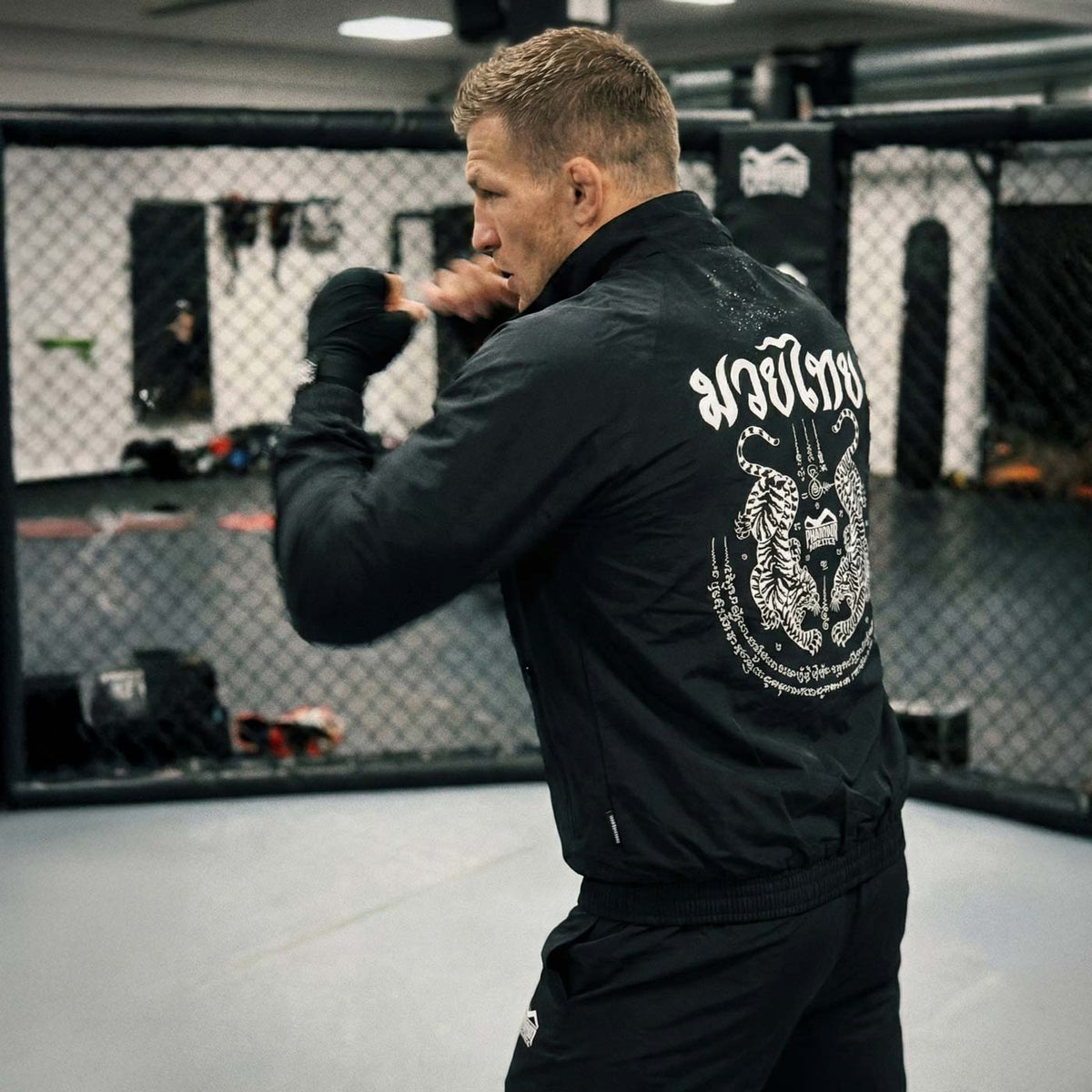 Performance‑Trainingsjacke im Muay Thai Stil von Phantom Athletics mit traditioneller Sak Yant‑Ästhetik, ideal für Aufwärm‑Runden und Athleten, die im Gym oder beim Sparring eine starke Präsenz zeigen. Leicht und funktional für intensives Training im Kampfsport.