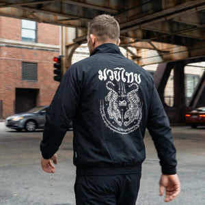 Premium Kampfsport‑Trainingsjacke Phantom Athletics DMC, inspiriert von Muay Thai und Sak Yant‑Kunst, für Training, Warm‑up und Freizeit im Fitness‑ oder Kampfsportstudio. Hochwertige Verarbeitung und modernes Design vereinen Stil und Funktion.
