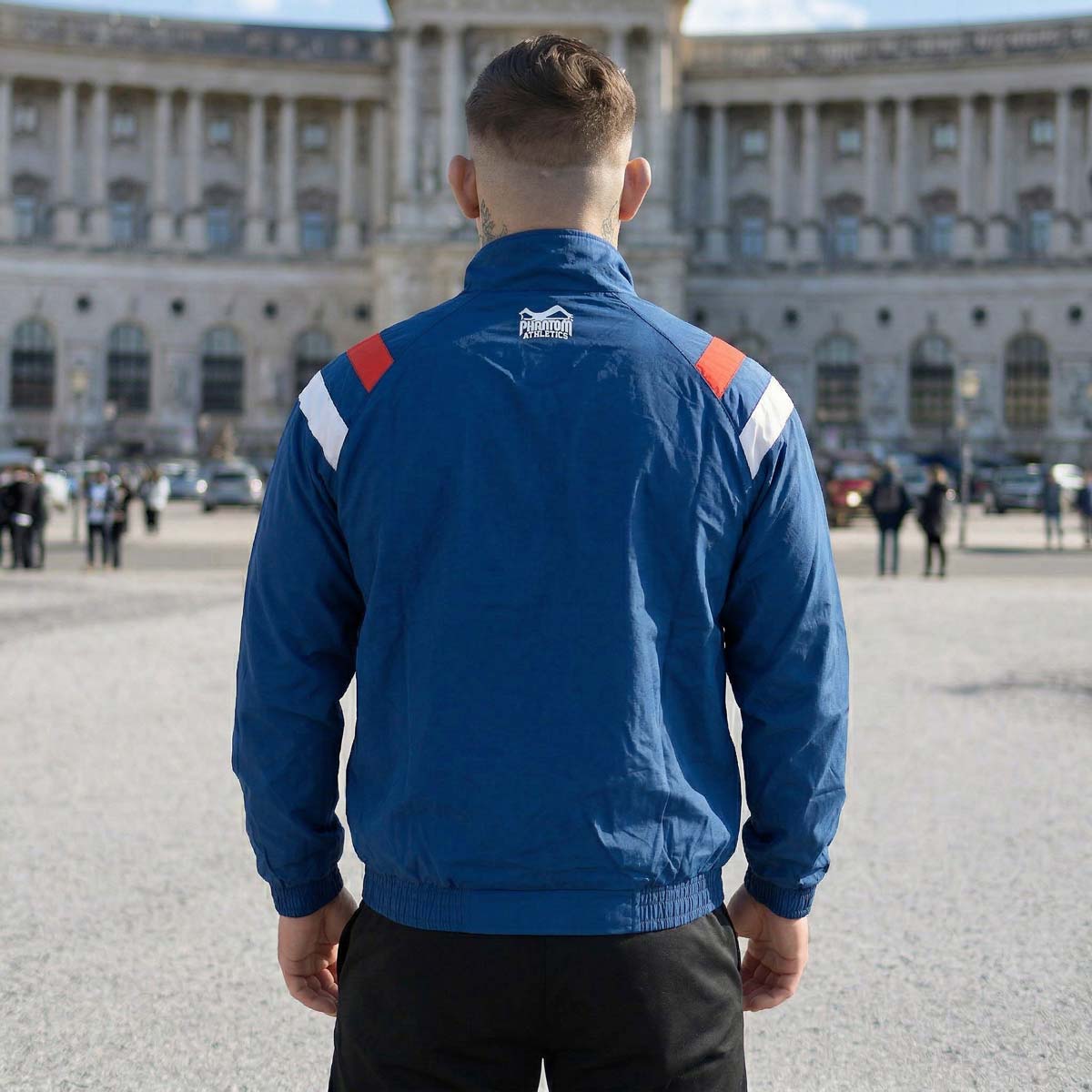 Die Phantom Athletics Track Jacket DMC Team Serbia in Blau kombiniert klassischen Retro-Style mit moderner Performance für intensives Kampfsport-Training wie MMA, Boxen und Muay Thai. Das leichte, atmungsaktive Material mit Mesh-Innenfutter sorgt für optimalen Komfort und maximale Bewegungsfreiheit beim Warm-up und Sparring.