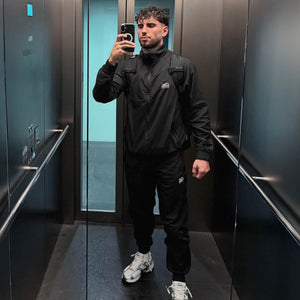 Hochwertige Phantom Athletics Track Pants DMC in klassischem Schwarz, ideal für Warm‑ups, Cool‑Downs und Training im MMA, Boxen oder Kickboxen mit komfortablem, atmungsaktivem Material für bewegungsreiche Sessions. Die sportliche Passform und elastische Bündchen sorgen für sicheren Sitz bei Technik‑, Kraft‑ und Sparring‑Einheiten im Gym. Ein Premium‑Trainingsteil für ambitionierte Kampfsportler.