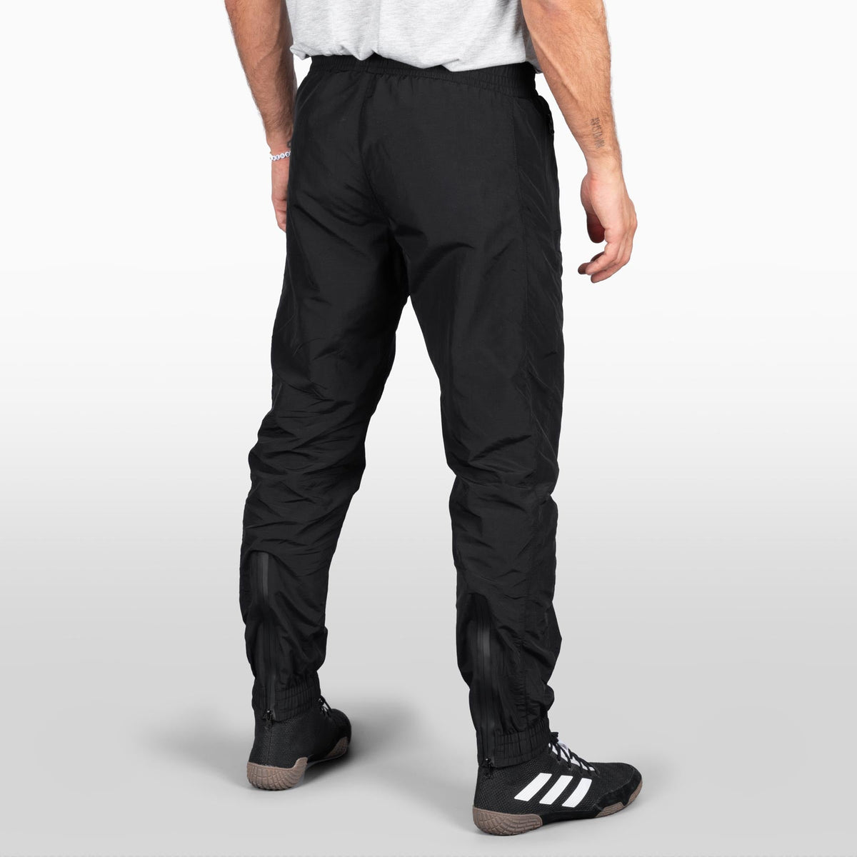 Tréninkový oblek DMC pro bojové umělce. Ideální pro wrestling, MMA, BJJ warm up nebo jogging. Kvalitní materiály a sportovní střih s čistým designem a zipy na nohavicích, takže se snadno obouvá i vyzouvá s botami.