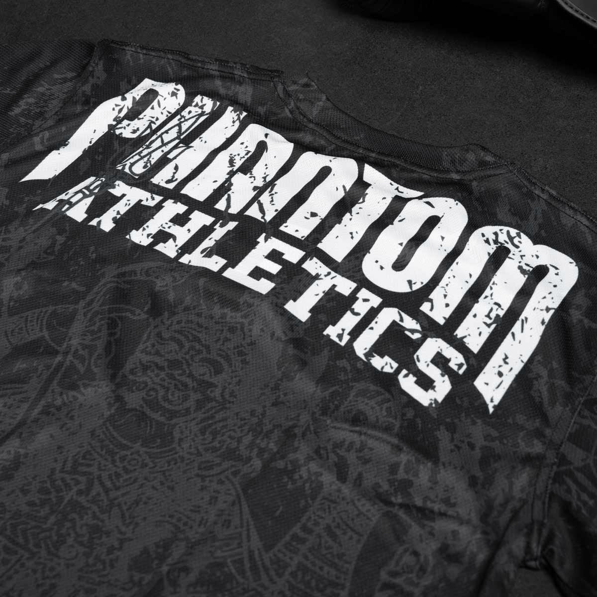 Phantom EVO Trainingsshirt im Muay Thai Design für Kampfsport Training. Mit thailändischer Schrift und Sak Yant Grafiken und großem Phantom Athletics Schriftzug.