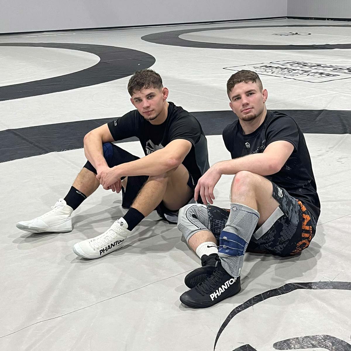Schwarze Phantom Athletics Ringerschuhe COMBAT, entwickelt für Wettkampf und Training im Ringen, Grappling und MMA, bieten hervorragenden Grip und hervorragende Kontrolle auf der Matte durch die speziell angepasste Split‑Sohle. Das atmungsaktive Mesh‑Material sorgt für ein trockenes Fußklima und optimalen Komfort bei intensiven Kampfsport‑Sessions, während Schnürung plus Klettverschluss sicheren Halt garantieren. Diese Premium‑Schuhe vereinen Performance, Stabilität und Stil für ambitionierte Athleten.