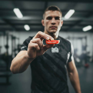 Der Phantom Athletics Apex Mundschutz in Rot bietet zuverlässigen Schutz für Kampfsportler in Disziplinen wie MMA, Boxen und Kickboxen. Dank der zweilagigen Konstruktion mit anpassbarem Gel-Kern sorgt er für optimalen Sitz und Komfort. Ideal für intensives Training und Sparring.