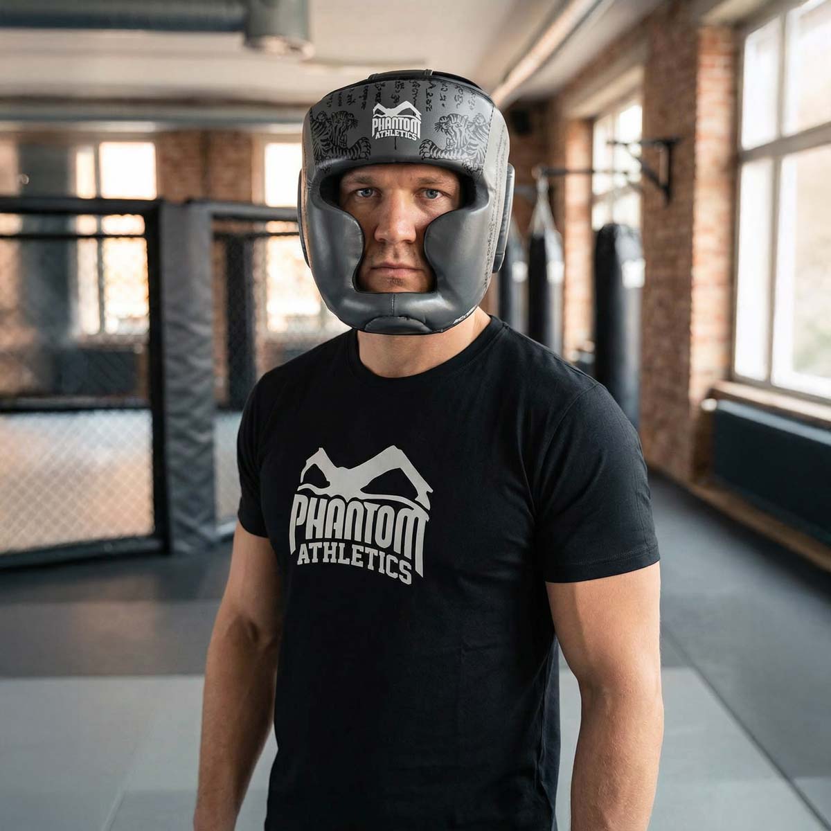 Robuster Phantom Athletics Muay Thai Headguard in Grau, entwickelt für intensives Sparring im Boxen, Kickboxen und MMA mit umfassendem Schutz für Stirn, Wangen und Kinn. Die dicke Polsterung absorbiert harte Treffer zuverlässig und sorgt für Komfort bei anspruchsvollen Trainings‑Sessions im Gym. Ein Premium‑Kopfschutz für ambitionierte Kampfsportler.