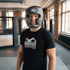 Robuster Phantom Athletics Muay Thai Headguard in Grau, entwickelt für intensives Sparring im Boxen, Kickboxen und MMA mit umfassendem Schutz für Stirn, Wangen und Kinn. Die dicke Polsterung absorbiert harte Treffer zuverlässig und sorgt für Komfort bei anspruchsvollen Trainings‑Sessions im Gym. Ein Premium‑Kopfschutz für ambitionierte Kampfsportler.