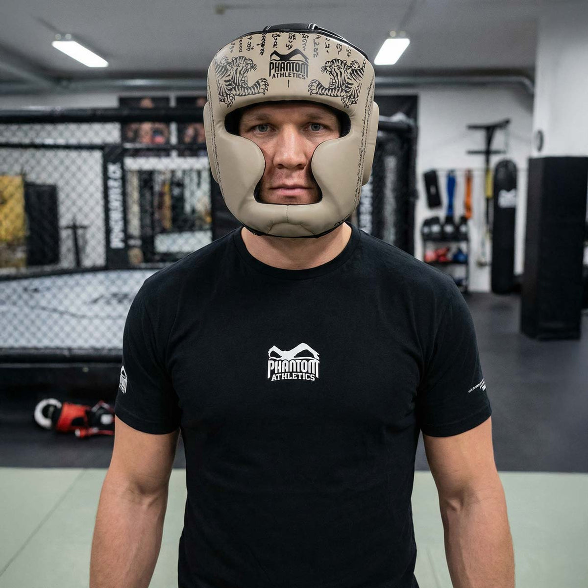 Robuster Phantom Athletics Muay Thai Headguard in Sand‑Beige, entwickelt für intensives Sparring und technikorientiertes Training im Thaiboxen, Kickboxen und MMA mit umfassendem Schutz für Stirn, Wangen und Kinn. Die dicke Polsterung absorbiert harte Treffer zuverlässig und sorgt für maximale Sicherheit im Gym. Ein Premium‑Kopfschutz für ambitionierte Kampfsportler.