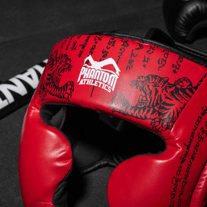 Phantom Muay Thai Kopfschutz für Thaiboxen und MMA Sparring, Wettkampf und Training. Im traditionellen Sak Yant Design und der Farbe Blau/Rot.