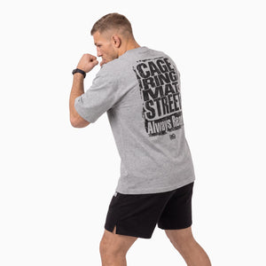Das Phantom Athletics Oversize T-Shirt CAGE RING MAT STREET in Grau steht mit dem „Always Ready“ Statement für Disziplin, Performance und die Mentalität echter Fighter. Der lockere Schnitt und das atmungsaktive Material machen es zur hochwertigen Kampfsportbekleidung für Training, Gym und Alltag.