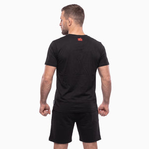 Das schwarze Phantom Athletics T-Shirt GERMANY NBD setzt mit dem roten Phantom Eagle und dem Schriftzug „NEVER BACK DOWN“ ein kraftvolles Statement für Entschlossenheit und Disziplin. Der sportliche Fighter-Look eignet sich perfekt für Kampfsport, Gym und Freizeit.