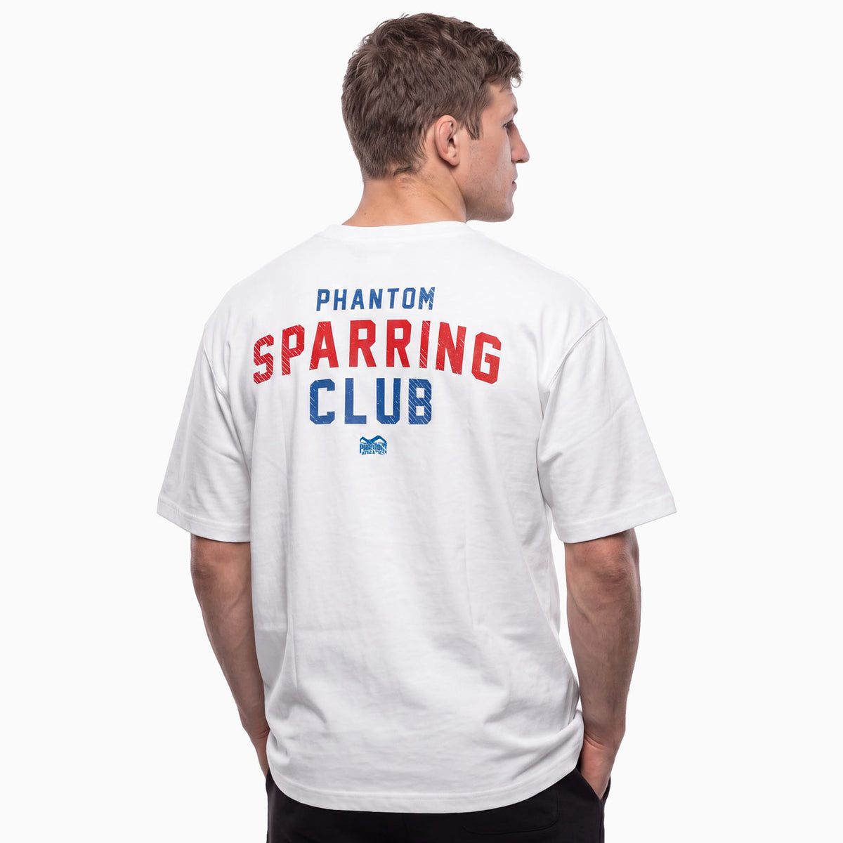 Das Phantom Athletics Oversize T-Shirt SPARRING CLUB in Weiß kombiniert einen lässigen Oversize Fit mit einem markanten Rückenprint im klassischen Gym-Style. Der rote und blaue SPARRING CLUB Schriftzug verleiht der hochwertigen Kampfsportbekleidung einen authentischen Look für MMA, Boxen, Kickboxen und Muay Thai.