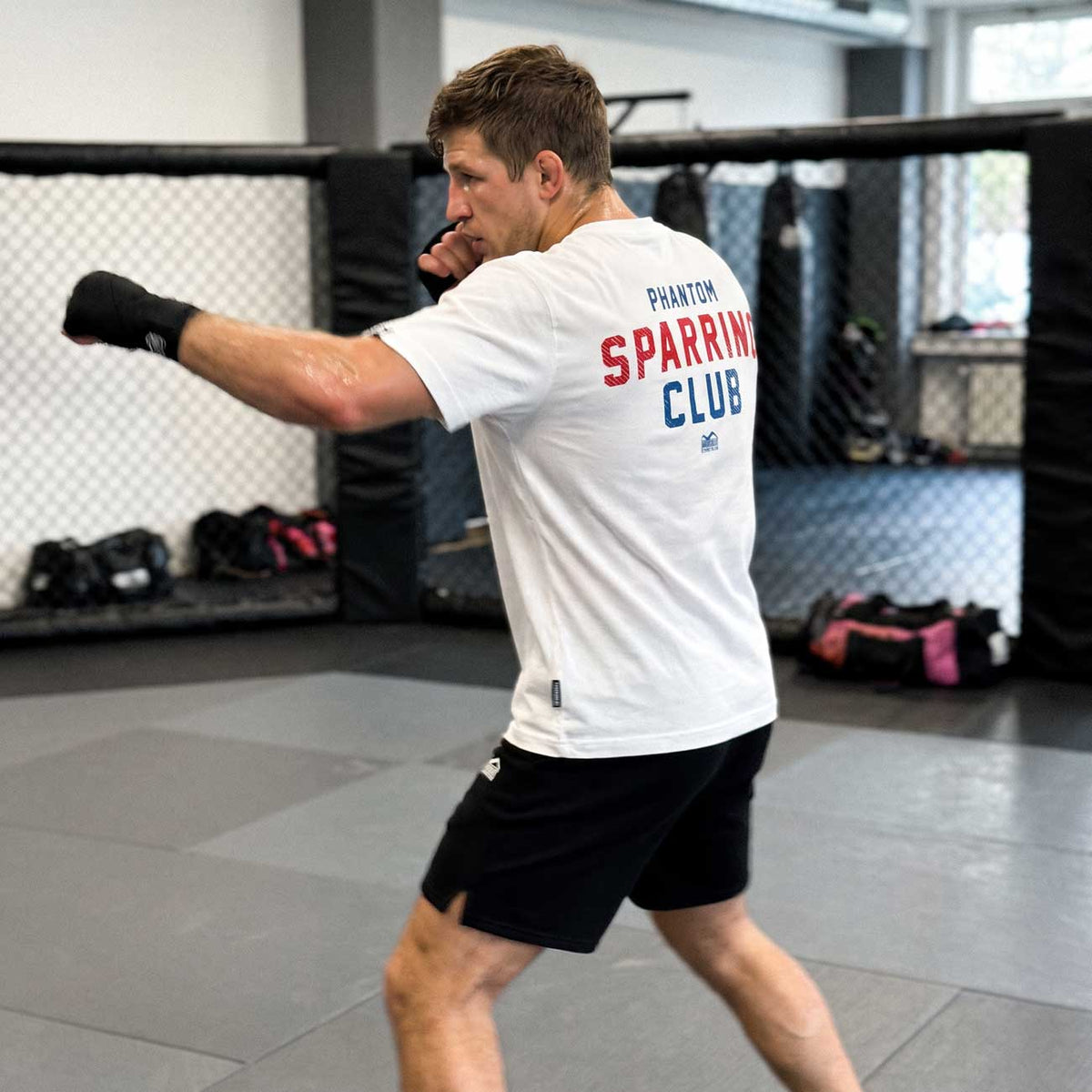 Das weiße Phantom Athletics Oversize T-Shirt SPARRING CLUB wurde für Athleten entwickelt, die Kampfsport und modernen Streetwear-Style verbinden möchten. Der atmungsaktive Materialmix und der Oversize Fit machen das Shirt zum komfortablen Begleiter für MMA, Kickboxen, Boxen, BJJ und Functional Fitness.