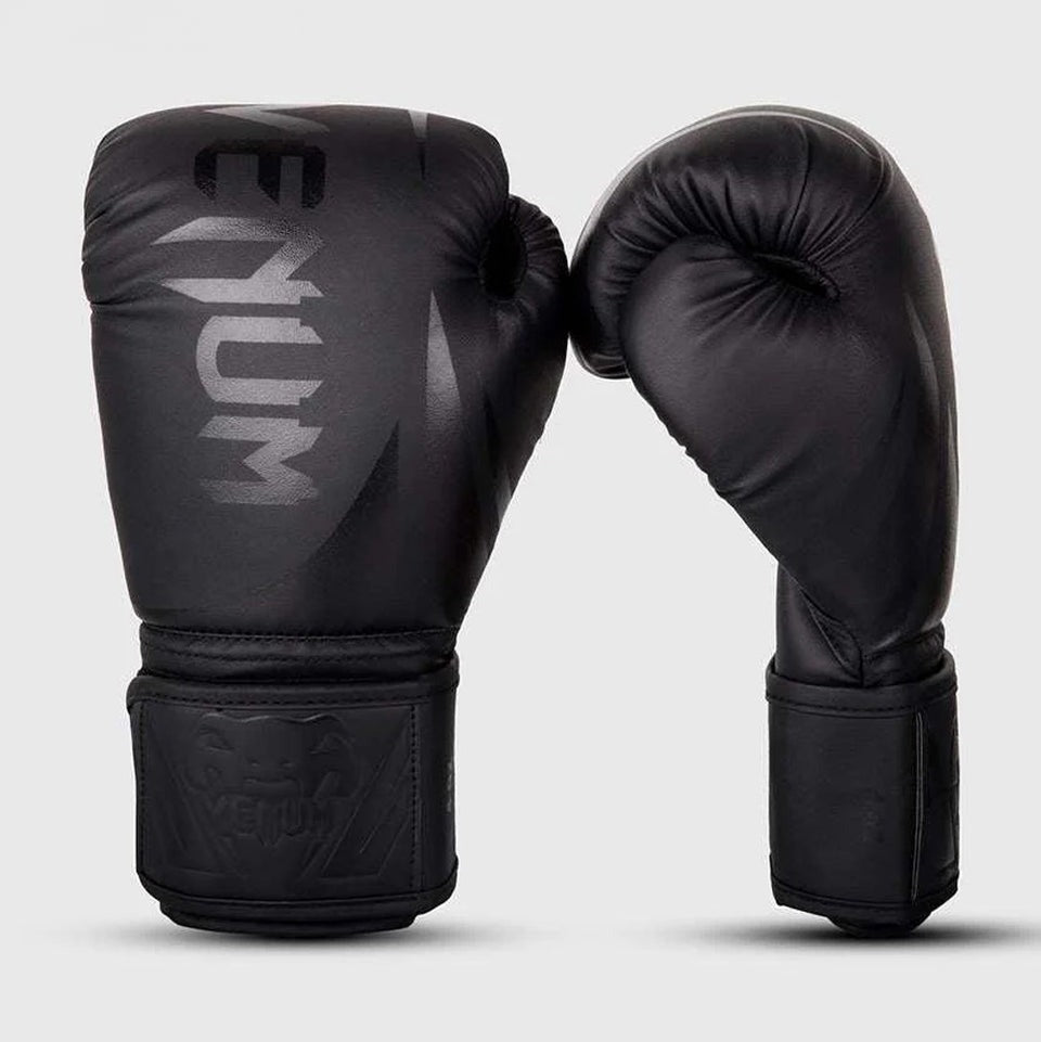 Die Venum Boxhandschuhe Challenger 3.0 in Schwarz bieten dank ihrer dreifachen Schaumstoffpolsterung optimalen Schutz bei jedem Schlag. Ideal für intensives Training, Sparring und Wettkämpfe im Boxen, Kickboxen und Muay Thai. Die robuste PU-Oberfläche garantiert Langlebigkeit und Strapazierfähigkeit.