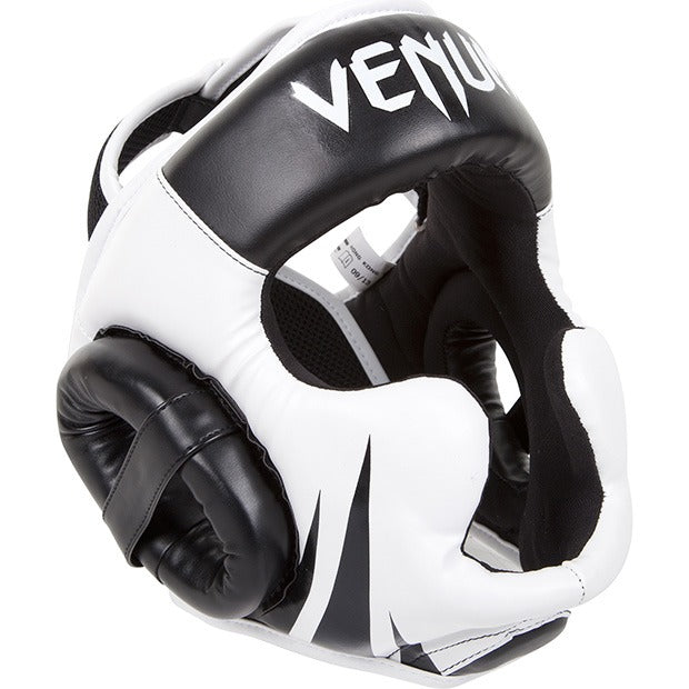 Hochwertiger Venum Kopfschutz Challenger 2.0 in Schwarz/Weiß, ideal für Sparring im MMA und Muay Thai. Dieser Kopfschutz schützt Stirn, Wangen, Kinn und Hinterkopf, ohne die Sicht zu beeinträchtigen. Perfekt für intensives Training und Wettkampf-Sparring als Teil deiner Kampfsportausrüstung.