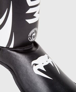 Venum Schienbeinschoner Challenger in Schwarz/Weiß – mit anatomischer Passform und robuster Polsterung, um Stöße aus dem Kick- oder Clinch-Bereich zu dämpfen. Der feste Sitz durch Klettverschlüsse verhindert Verrutschen auch bei intensiven Bewegungen. Eine Top-Wahl für dein Muay Thai, K1 oder Kickboxtraining.