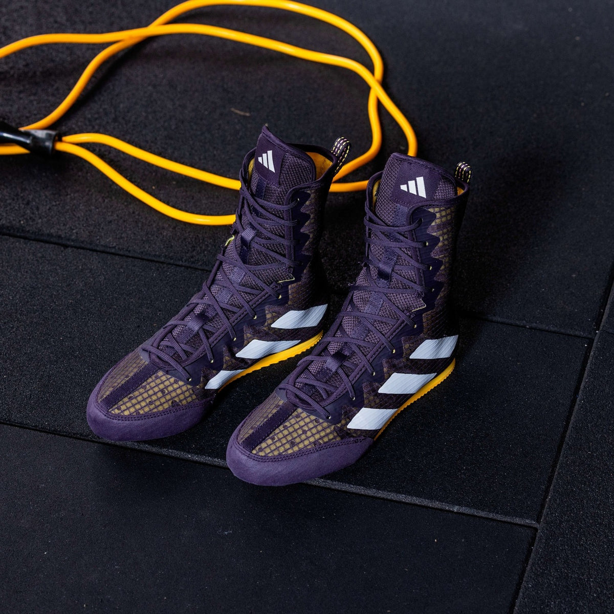 Hochwertige Boxschuhe in Lila von adidas, die speziell für den anspruchsvollen Einsatz im Kampfsport konzipiert wurden. Ihre griffige Sohle sorgt für perfekten Halt auf jedem Boxboden.