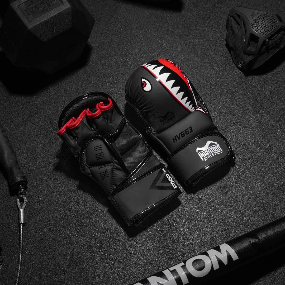 Die Phantom Fightsquad MMA Sparringshandschuhe am Gymboden neben der Phantom Trainingsmaske