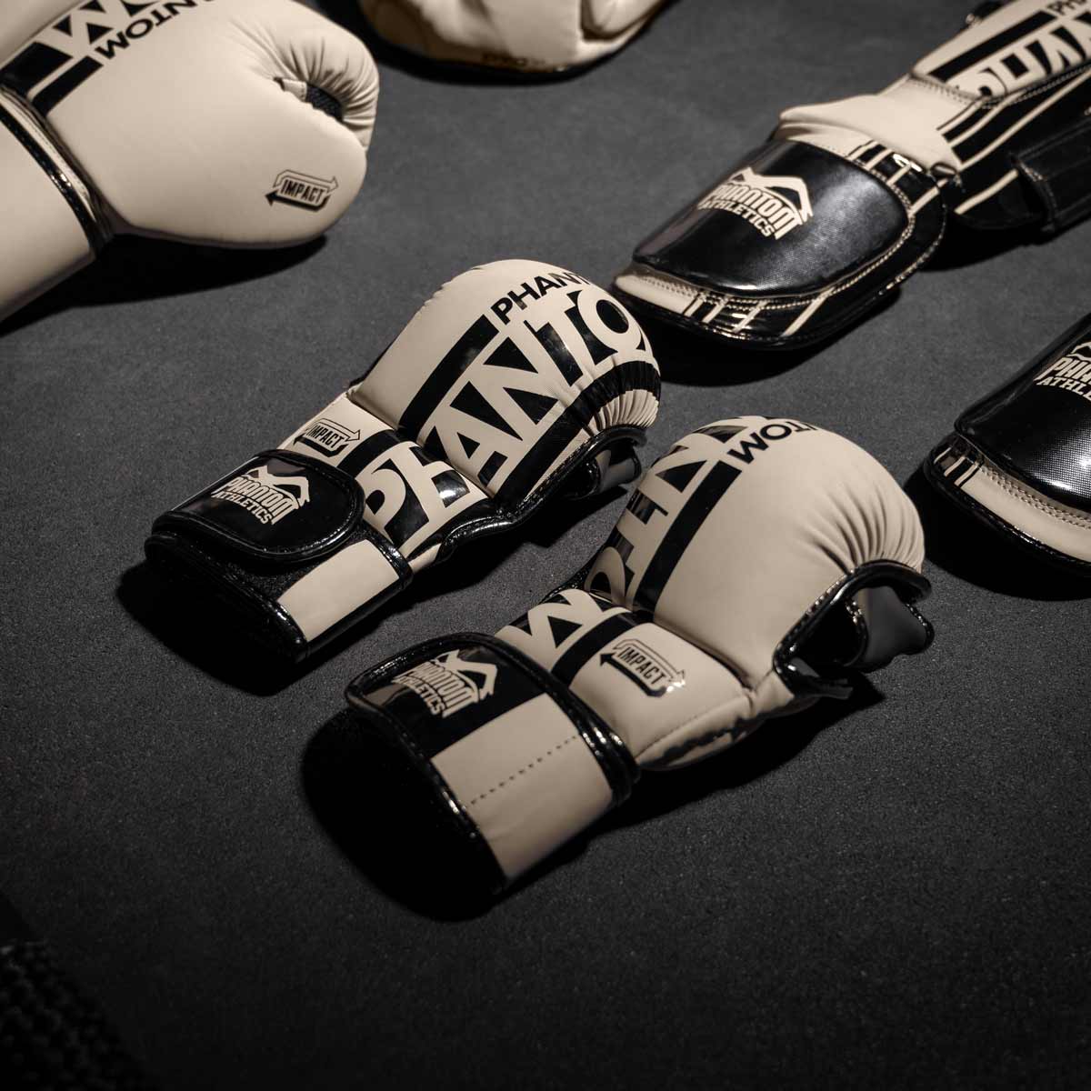 Die Phantom MMA Sparringshandschuhe APEX zusammen mit den APEX Boxhandschuhen und Hybrid Schienbeinschonern in Sand
