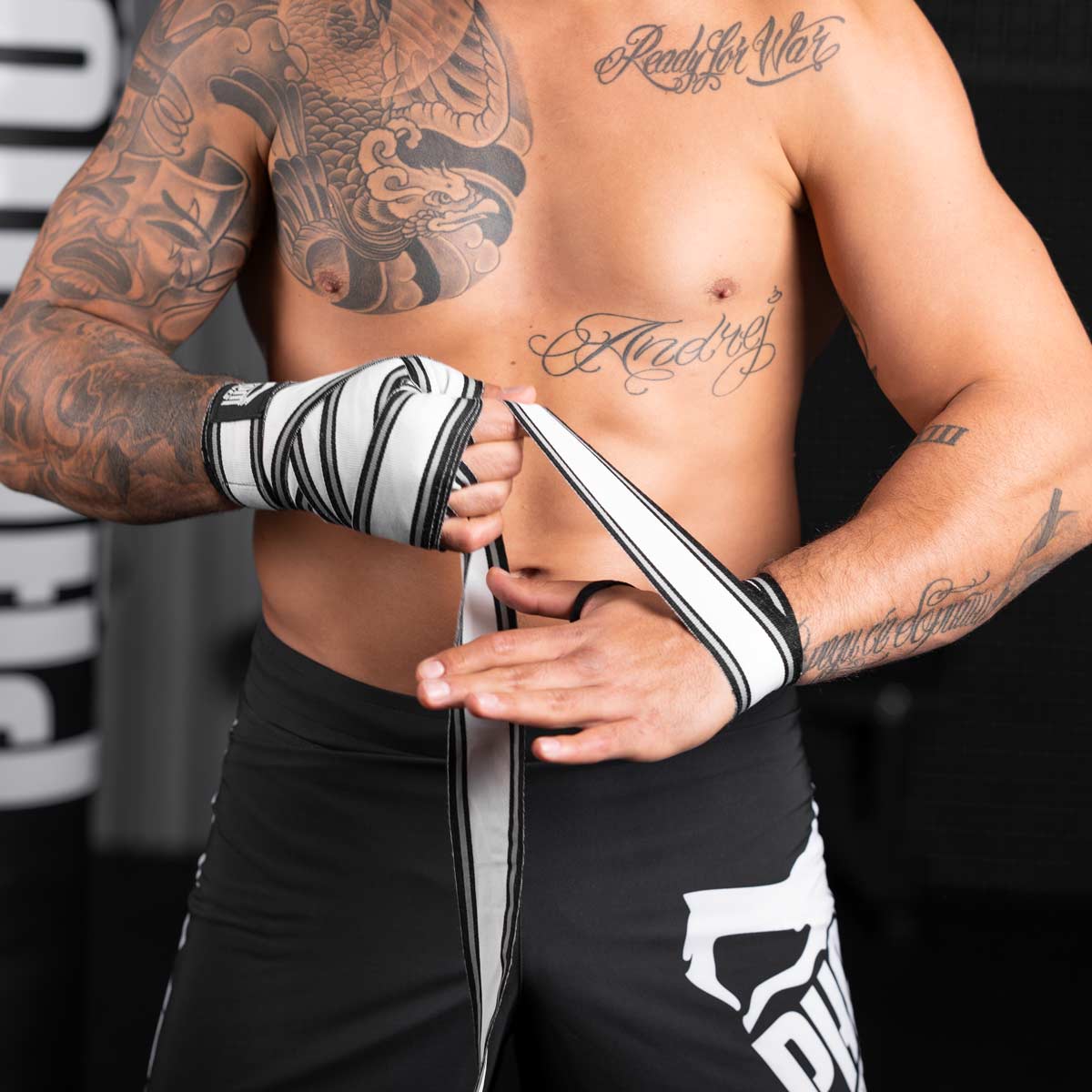 Phantom Boxbandagen für dein Kampfsporttraining.  Ideal für MMA, Muay Thai und Kickboxen. 450cm in den Farben Schwarz/Weiss. UFC Fighter Aleks Rakic beim Binden vor dem Training. 