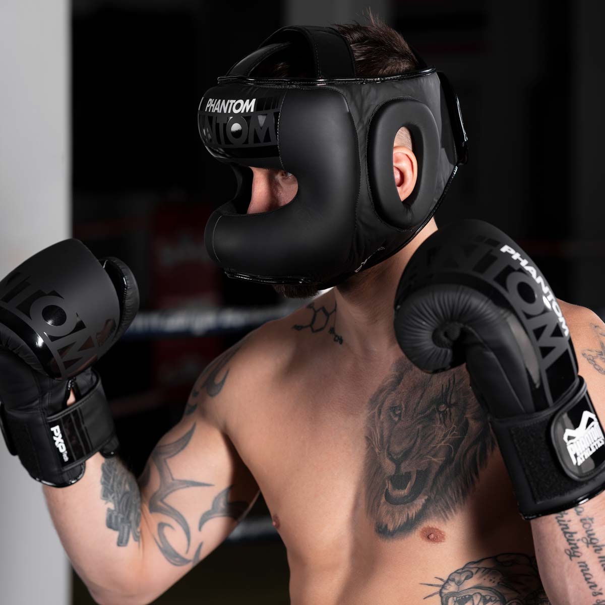 Muay Thai Fighter mit dem Phantom APEX Face Saver Kopfschutz und den Phantom Apex Boxhandschuhen