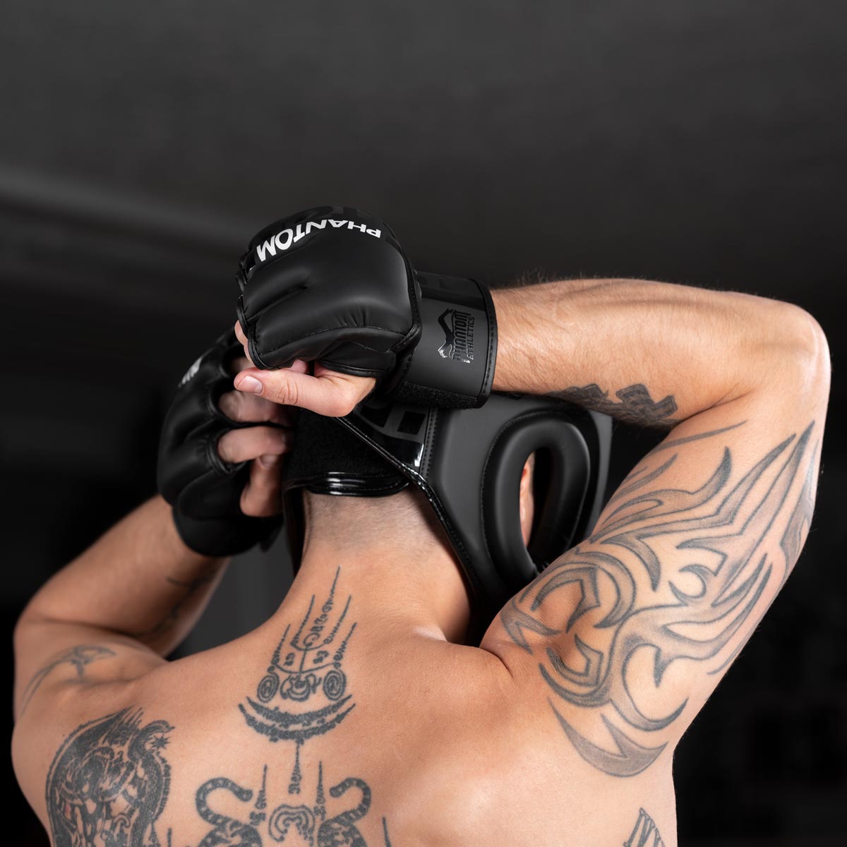 MMA Fighter schließt den Phantom MMA Kopfschutz fürs Sparring mit den Phantom Apex MMA Fight Handschuhen