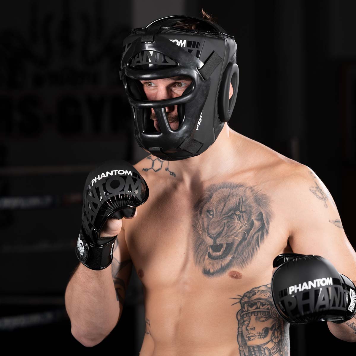 Muay Thai Profi im Training mit dem Phantom Cage Kopfschutz und den APEX MMA Sparringshandschuhen