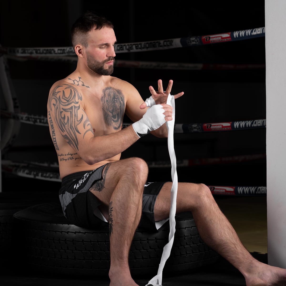 Muay Thai Profi im Gym beim Binden der Phantom weissen Impact Boxbandagen