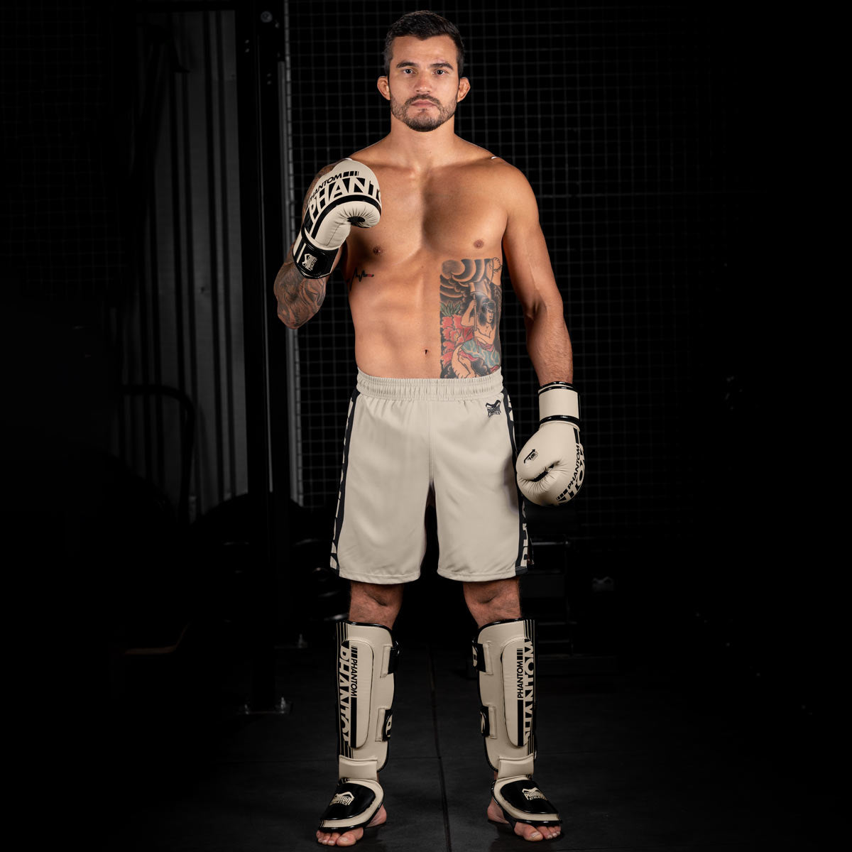 MMA Fighter im Gym mit der Sand farbenen Apex Fight Collection bestehend aus Boxhandschuhen, Hybrid Schienbeinschonern und Apex MMA Fightshorts.