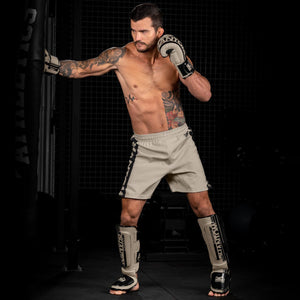 Die Phantom EVO Fightshorts sind die idealen Shorts für deinen Kampfsport. Ganz egal ob MMA, BJJ, Kickboxen oder Muay Thai. Durch das ultraleichte, elastische, reissfeste und schnelltrocknende Material bieten sie die volle Bewegungsfreiheit und maximalen Komfort, so dass du dich ganz auf deinen Fight oder dein Training konzentrieren kannst. Hier in der Farbe Sand Beige. MMA Fighter beim Sandsack Training. 