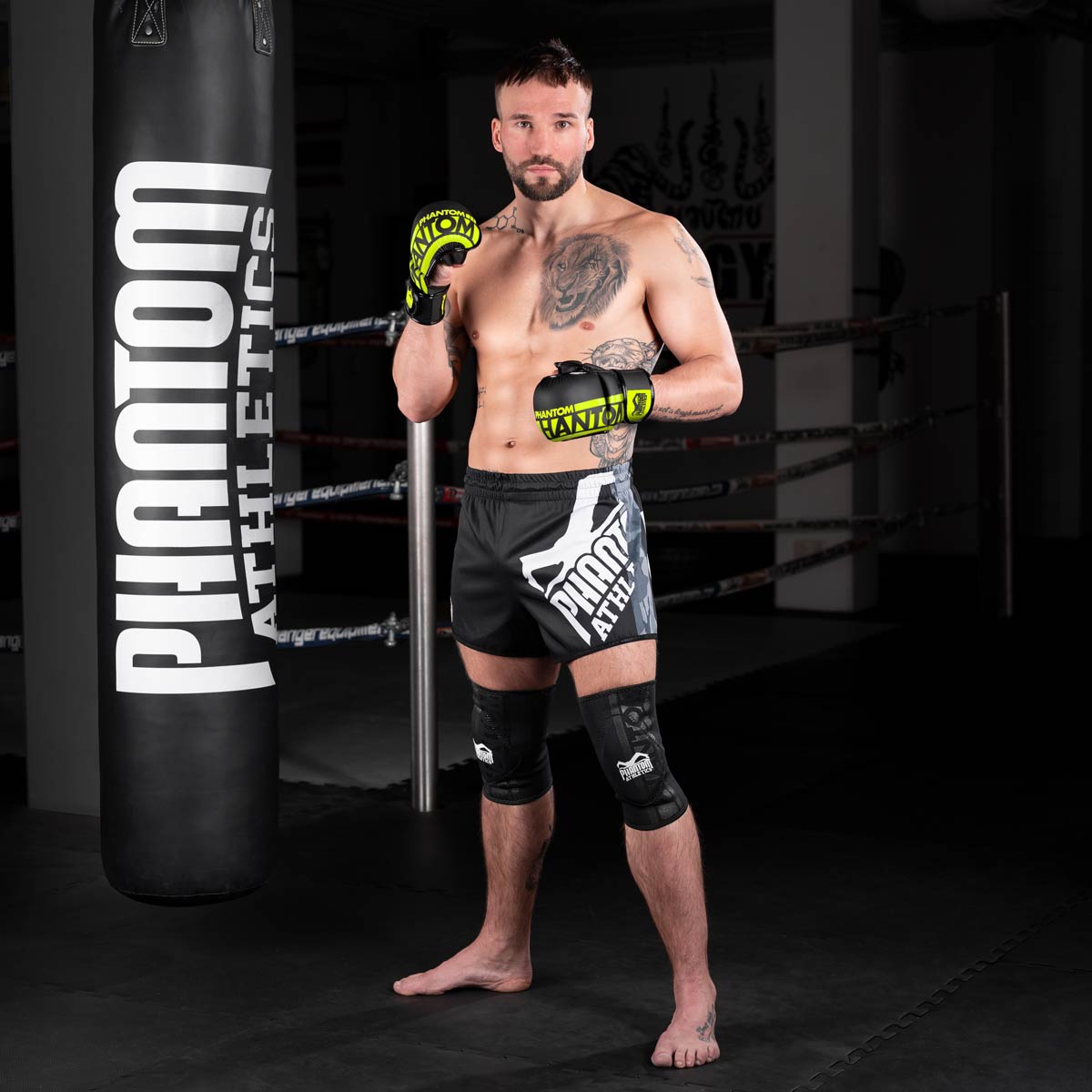 Fight Profi im Gym mit den Phantom Apex MMA Sparringshandschuhen vorm Sandsack Training