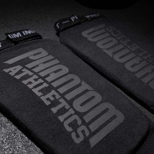 Phantom Athletics Impact Schienbeinschutz in klassischem Schwarz – bietet starken Knöchel- und Schienbeinschutz bei vollem Bewegungsspielraum. Ideal für intensives Training im Standkampf.