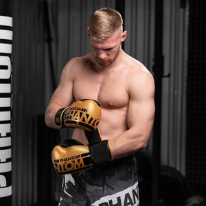 Goldene Boxhandschuhe mit elastischem Verschluss von Phantom Athletics – ideal für dynamische Trainingseinheiten und Sparring. Hochwertiges Kunstleder für lange Haltbarkeit.