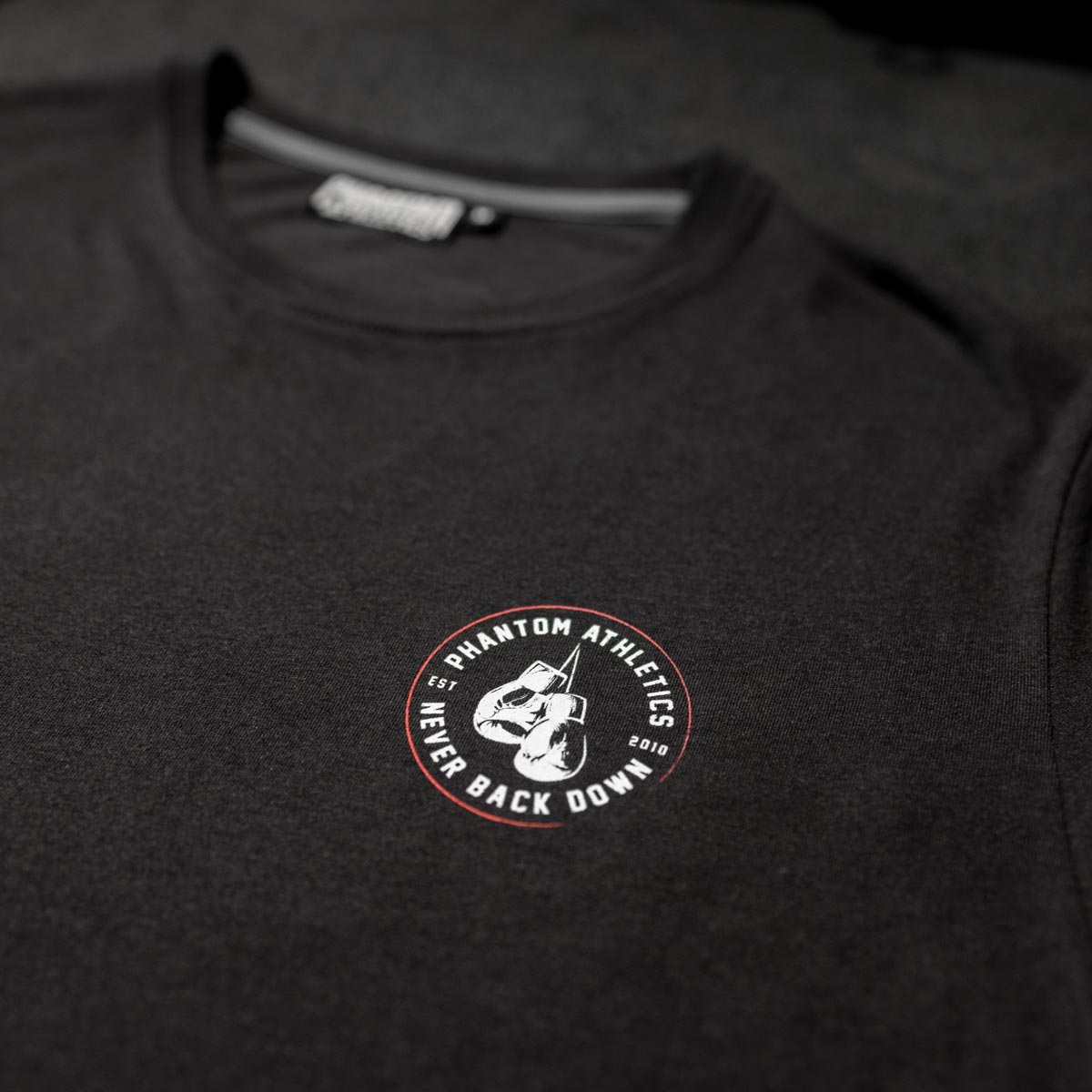 Phantom Athletics T-Shirt &quot;Never Back Down&quot;, ein Must-Have für MMA- und Thaibox-Enthusiasten. Das hochwertige Material bietet Komfort und Bewegungsfreiheit für Schläge, Tritte und Grappling-Techniken.