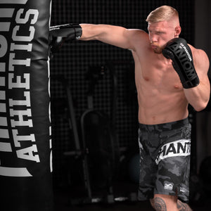 Die Phantom Boxhandschuhe APEX Laced. Mit Schnürung für Profi Training und Wettkampf.  Kickboxer beim Sandsacktraining. 