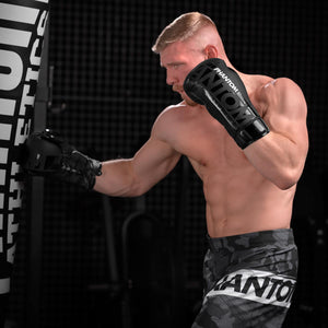 Die Phantom Boxhandschuhe APEX Laced. Mit Schnürung für Profi Training und Wettkampf.  Kickboxer beim Sandsacktraining. 